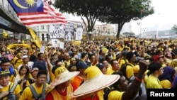 Para demonstran mendengarkan pidato dalam protes yang diorganisir oleh kelompok pro-demokrasi "Bersih" di Kuala Lumpur (29/8). (Reuters/Olivia Harris)