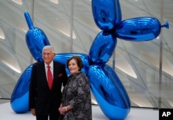 Eli Broad and his wife Edythe pose for a photo in front of a Jeff Koons sculpture at Broad's new museum called "The Broad" in downtown Los Angeles, Sept. 16, 2015.