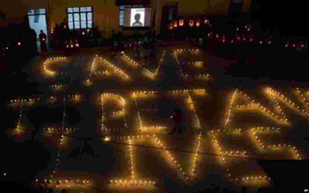 Exile Tibetans arrange candles to read 'Save Tibetans Lives' during a protest vigil to remember Tibetans who have self-immolated in Tibet this year, in Dharmsala, India, Saturday, Oct. 8, 2011.