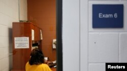 Una mujer habla con un empleado en una sala de examen durante una visita de los medios a un centro de detención de ICE, en Tacoma, Washington, el 16 de diciembre de 2019.