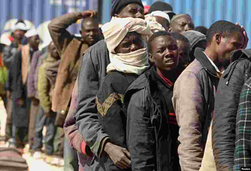 Migrant workers from Africa stand in a line after they arrive by ship from Misrata during an evacuation operation organized by the International Organization for Migration (IOM) at the port of Benghazi May 5, 2011. REUTERS/Mohammed Salem