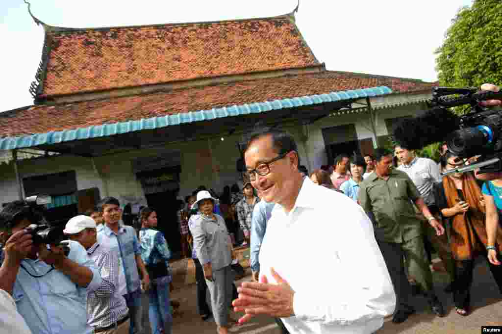 Sam Rainsy, president of the Cambodia National Rescue Party (CNRP), visits a polling station during the general elections in Phnom Penh, July 28, 2013. 