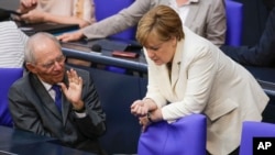 German Chancellor Angela Merkel, right, talks with Finance Minister Wolfgang Schaeuble prior to a debate about the British vote to leave the EU, in Berlin, June 28, 2016.