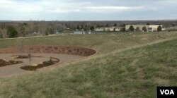 The Columbine Memorial (left) just over the hill from Columbine High school (right) in Littleton, Colorado. (M. Burke/VOA)