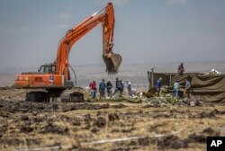 Para penyelidik sedang bekerja di lokasi kecelakaan pesawat Ethiopian Airlines Boeing 737 Max 8, yang jatuh beberapa menit setelah lepas landas, menewaskan seluruh 157 penumpang, dekat Bishoftu, tenggara Addis Ababa, Ethiopia, 15 Maret 2019.