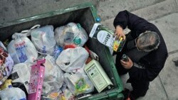 A man empties the remains of an olive oil container from a trash bin in the Greek city of Thessaloniki in January