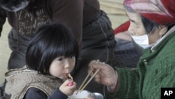 A child eats noodle during a lunch at an evacuation center in Ofunato, Iwate Prefecture, Japan, Sunday, March 20, 2011, after the March 11 earthquake and tsunami devastated the area. (AP Photo/Koji Sasahara)