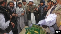 Afghan men pray during the funeral of Najia Sidiqi, the acting director of the women's affairs department in Mihtarlam, December 10, 2012.