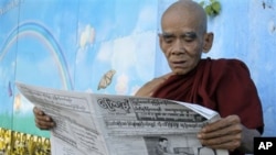 A Buddhist monk reads a newspaper outside the Jivita Dhana Free Hospital for Buddhist Monks in Rangoon, Burma, one day after the first elections in 20 years, 08 Nov. 2010.