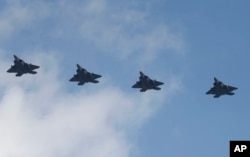 FILE - Four U.S. F-22 stealth fighters fly over Osan Air Base in Pyeongtaek, South Korea, Wednesday, Feb. 17, 2016.