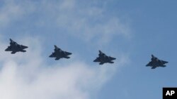 Empat pesawat jet siluman AS F-22 terbang di atas Pangkalan AL di Pyeongtaek, Korea Selatan, Rabu, 17 Februari 2016.