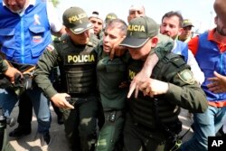 FILE - Colombian police escort a Venezuelan soldier who surrendered at the Simon Bolivar international bridge, where Venezuelans tried to deliver humanitarian aid despite objections from President Nicolas Maduro, in Cucuta, Colombia, Feb. 23, 2019.