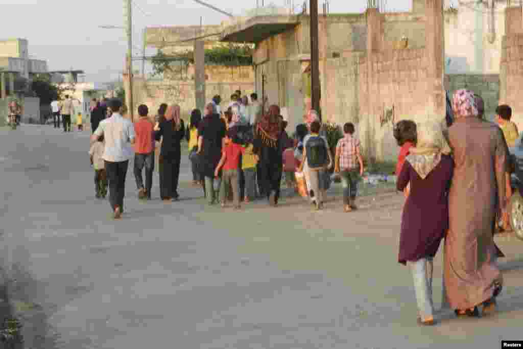 Residents flee their homes after shelling in Houla near Homs, Syria, June 18, 2012.