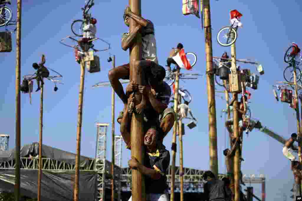 Những người tham dự cuộc tranh tài leo cột mỡ được tổ chức tại Công viên Jaya Ancol Dream ở Jakarta, để kỷ niệm lần thứ 68 ngày Indonesia giành được Độc lập từ Hà Lan.