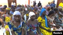 A still image taken from video shows a group of girls, released by Boko Haram jihadists after kidnapping them in 2014 in the north Nigerian town of Chibok, sitting in a hall as they are welcomed by officials in Abuja, Nigeria, May 7, 2017. 