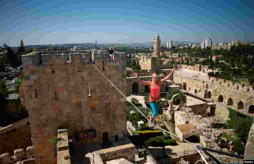 Seorang atlet slackliner Amerika, Heather Larsen, melintas di atas kawat yang terbentang tinggi di antara dua menara di Museum Menara David di Kota Tua Jerusalem.&nbsp; Dengan mengenakan sabuk pengaman yang dikaitkan pada kawat, Larsen berjalan melintasi rentang kawat sepanjang 35 meter dan kemudian kawat sepanjang 20 meter di lingkungan lapangan sebelah dalam di museum tua Menara Daud Jerusalem, yang dinamakan sesuai dengan nama raja yang disebutkan dalam Alkitab, 2 Mei 2016.