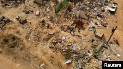 Houses and other buildings were destroyed when a vehicle carrying mining explosives detonated along a road in Apiate, Ghana, Jan. 21, 2022.