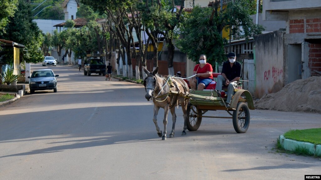 A couple rides on a horse carriage, in Alpercata, Minas Gerais state, Brazil, November 4, 2021. Picture taken November 4, 2021. (REUTERS/Washington Alves)