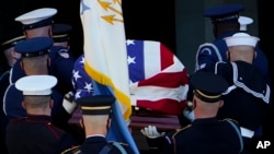 Sèkèy ansyen Sekretè d'Eta Etazuni Colin Powell gen yon drapo ki vlope l nan moman y ap antre avè l nan Katedral Nasyonal la pou fineray li nan Washington, Vandredi 5 Nov. 2021.