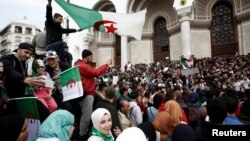 FILE - People carry national flags and banners during a protest calling on President Abdelaziz Bouteflika to quit, in Algiers, Algeria, March 26, 2019. 