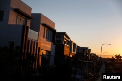 FILE - New million-dollar homes are pictured under construction at sunset in southern Sydney, Aug. 14, 2014. More wealthy Chinese are moving their money out of China to invest in Australia's property market.