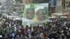 Supporters of the opposition Sierra Leone People's Party (SLPP) march through central Freetown with a placard of presidential candidate Julius Maada Bio and his running mate, Dr. Kadi Sesay, in Freetown, Sierra Leone, October 19, 2012. 