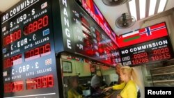 Customers buy and sell money at a currency exchange office in Istanbul, Turkey September 27, 2021.