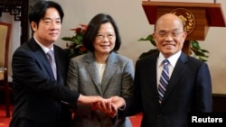 Former premier William Lai, left, Taiwan President Tsai Ing-wen and new premier Su Tseng-chang, right, join hands after a news conference in Taipei, Taiwan, Jan. 11, 2019.