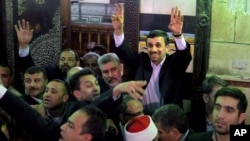 Presiden Iran Mahmoud Ahmadinejad melambai kepada warga Mesir setelah mengunjungi makam Imam Hussein di Kairo, Mesir (5/2). 