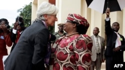 FILE - International Monetary Fund Managing Director Christine Lagarde is greeted by Malawi’s President, Joyce Banda, on arrival at Kamuzu Palace in Lilongwe on her three-day official visit to Malawi, Jan. 4, 2013.
