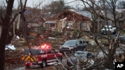 An emergency vehicle drives through a neighborhood in Rowlett, Texas, Dec. 27, 2015, the morning after it was struck by a tornado. 