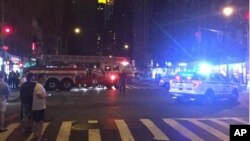 Polisi dan petugas pemadam kebakaran berada di lokasi ledakan di kawasan Chelsea, Manhattan, New York Sabtu malam (17/9).