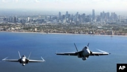 Two Royal Australian Air Force fighter jets, an F/A-18 Hornet (L) and an F/A-18F Super Hornet, fly over Port Philip Bay as part of the Australian International Airshow in Melbourne on March 2. (Reuters/Commonwealth of Australia)