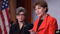 Sen. Jeanne Shaheen, D-N.H., right, standing with Sen. Joni Ernst, R-Iowa, announces in Washington, Feb. 7, 2018, a bipartisan resolution that would establish a special Senate committee to investigate the USOC and USA Gymnastics regarding how team doctor Larry Nassar was allowed to sexually abuse female gymnasts over decades. 