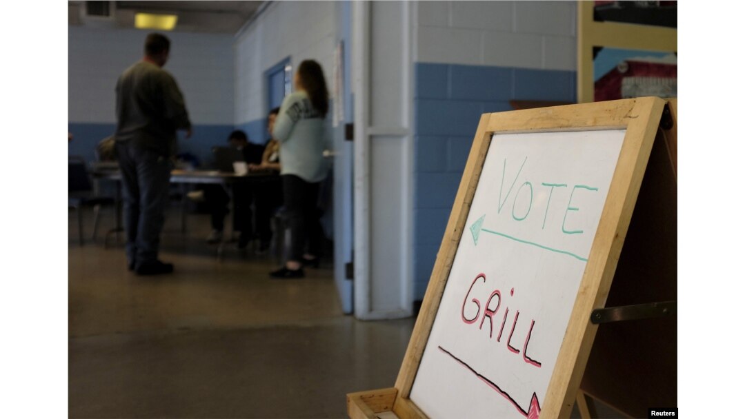 FILE - A voter checks in with workers at a polling station in Kershaw, S.C., Feb. 27, 2016. Democrats and Republicans compete in primaries and caucuses in at least 11 states and one U.S. territory Tuesday.