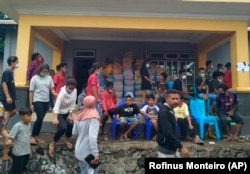 Warga yang terdampak banjir bandang akibat siklon tropis Seroja mendatangi tempat distribusi bantuan di Ile Boleng di Pulau Adonara, Nusa Tenggara Timur, 7 April 2021. (Foto: Rofinus Monteiro/AP)