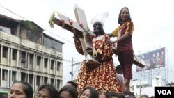 Para wanita penganut agama Katholik di Manila berjalan bertelanjang kaki menggusung replika Black Nazarene. Ribuan warga Filipina berpartisipasi dalam arakan tahunan patung kayu hitam Yesus dari Nazareth, Minggu (8/1). Patung ini dipercaya memiliki khasia