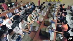 Chinese youths use computers at an Internet cafe in Beijing, June 2005 (file photo)