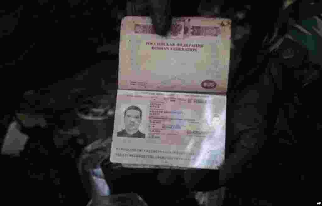 Passport of a flight engineer on the Sukhoi Superjet-100 is held by a rescue worker at Mount Salak in Bogor, Indonesia, Friday, May 11, 2012. Search teams who scaled a volcano's steep slopes found at least 12 bodies Friday near the wreckage of a Russian-m