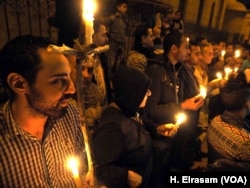 Egyptian Copts seen lighting candles during a vigil in front of the "Botrosia" church, 35 were announced injured in Abbassya as they attended a vigil in Cairo, Dec. 11, 2016.
