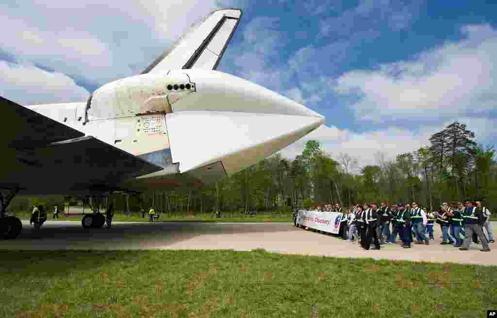 Workers from NASA Kennedy Space Center and United Space Alliance follow space shuttle Discovery as it arrives at the Steven F. Udvar-Hazy Center in Chantilly, Virginia. (NASA/Carla Cioffi)