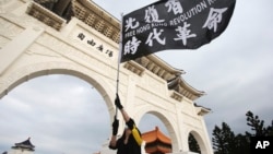 台灣民眾在台北自由廣場揮舞旗幟紀念百萬人反送中大遊行一周年並抗議港版國安法。（2020年6月13日）