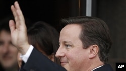 Britain's Prime Minister David Cameron waves as he arrives back at his hotel on the first day of the Conservative Party's annual conference in Manchester, October 2, 2011.