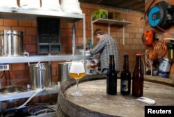 Jeff, member of the Belgian Homebrewers association, pours his own beer in the garage of his house in Sombreffe, Belgium, Aug. 9, 2016.