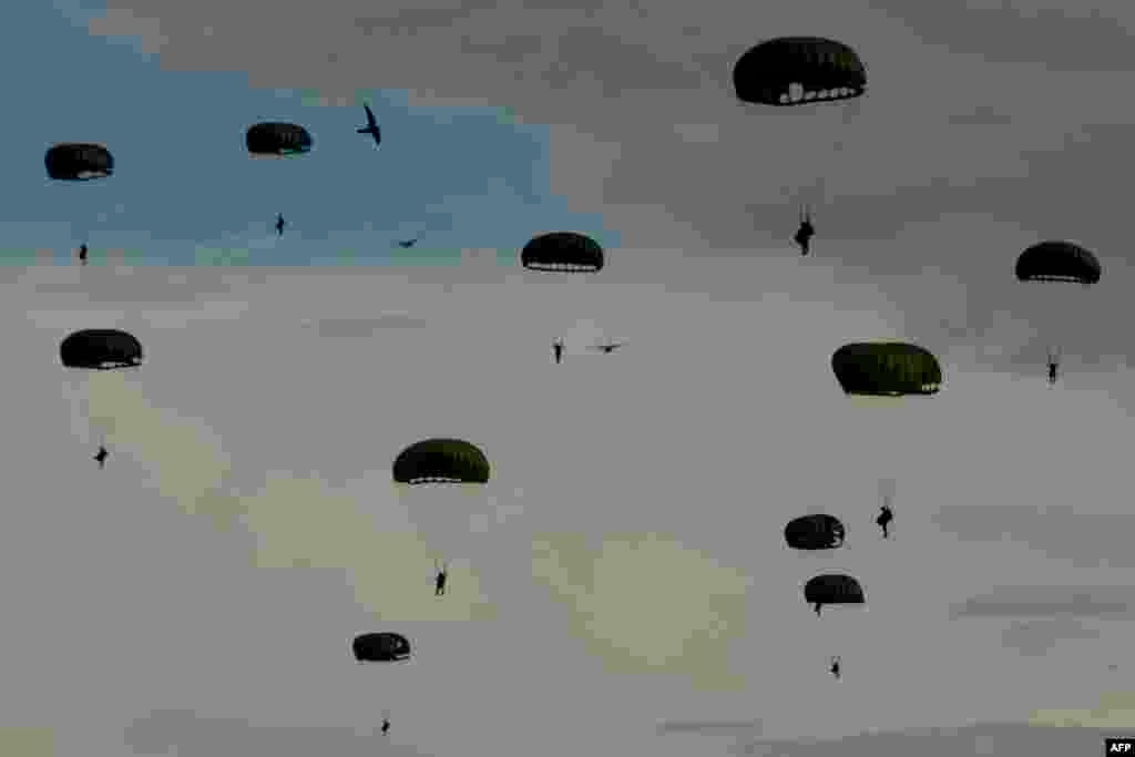 Indonesian paratroopers descend with their chutes during the Jalak Sakti military exercise held at the Sultan Iskandar Muda Air Force Base in Blang Bintang, Aceh province.