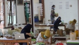 Organizers prepare packages of items to be shipped to customers during Pahingan Sunday Market in Jakarta, Indonesia, Sunday, Nov. 29, 2020. (AP Photo/Achmad Ibrahim)
