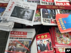 FILE - A front page of a Chinese newspaper with a photo of U.S. President-elect Donald Trump and the headline "Outsider counter attack" is displayed at a newsstand in Beijing, China, Nov. 10, 2016.