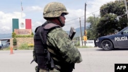 A Mexican soldier stands guard at a checkpoint in Iguala, Guerrero State, Mexico, Sept. 29, 2014, following recent clashes that led to at least six deaths.