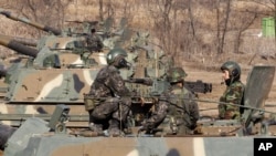 3月11日在朝鲜与韩国边境附近的村庄板门店，韩国士兵坐在自动推进的炮车上，他们正在进行军事演习以应对可能来自朝鲜的打击。