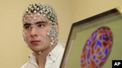 In this May 31, 2013, photo, research assistant Kevin Real wears an EEG net for detecting brain activity which is hooked up to a monitor, at the University of Nebraska's Center for Brain, Biology and Behavior in Lincoln, Nebraska. (AP Photo/Nati Harnik)